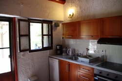 kitchen with fridge, oven with three hobs and single bed.